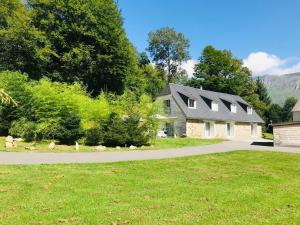 a house with a driveway in front of a yard at Le Nid Montagnard in Aucun