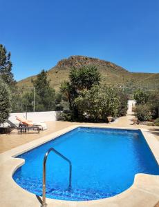 a large blue swimming pool in front of a mountain at Casa el Olivo in Mazarrón