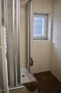 y baño con ducha y puerta de cristal. en Kontorhaus Senftenberg, en Senftenberg