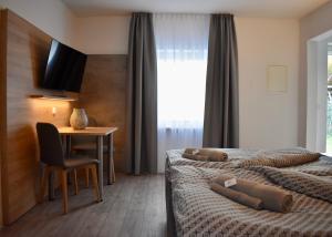 um quarto de hotel com duas camas e uma mesa e uma secretária em Kontorhaus Senftenberg em Senftenberg