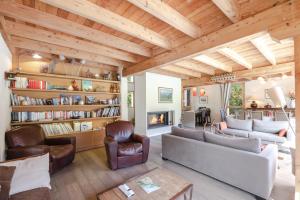 a living room with wooden ceilings and a fireplace at Chalet Athina in Les Houches