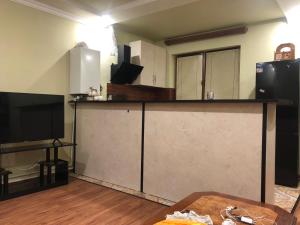 a kitchen with a counter with a tv and a table at Yerevan Qanaqer House in Yerevan