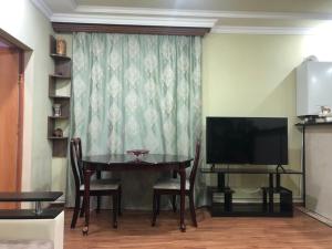 a dining room with a table and a television at Yerevan Qanaqer House in Yerevan