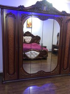 - un grand miroir dans une chambre avec un lit dans l'établissement Yerevan Qanaqer House, à Erevan