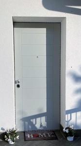una puerta a un edificio con dos plantas delante de él en SleepWell in Valganna, en Valganna