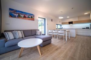 a living room with a couch and a table and a kitchen at Holiday House U Hájenky 13P Lipno Home in Lipno nad Vltavou