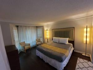 a hotel room with a bed and a chair at Large Modern Southern Pool Home Near Shops in Memphis