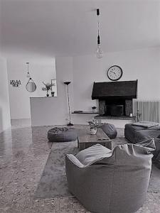 a living room with a couch and a clock on the wall at SleepWell in Valganna in Valganna