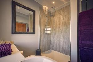 a bathroom with a shower and a sink and a mirror at Host & Stay - Bluebell Cottage in Belford