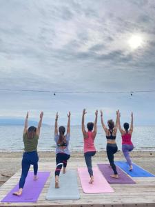 een groep vrouwen die yoga doen op het strand bij SEAVIEW BEACH RESORT in Sibulan