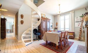 ein Esszimmer mit einem Tisch und einer Wendeltreppe in der Unterkunft Appartement de 2 chambres avec vue sur la ville et wifi a Saumur in Saumur