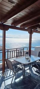 a table and chairs on a balcony with the ocean at Blue Seaview Suites in Piraeus