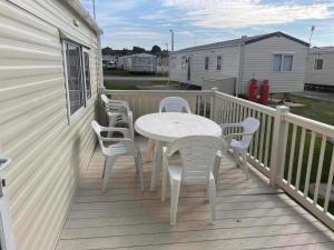 a white table and chairs on a deck at 2 bedroom caravan in hunstanton free wi-fi in Hunstanton