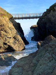 a bridge over a body of water with a river at Sirens Sunset Peaceful Retreat with stunning sea views, 5 minutes from Porth Beach in Newquay