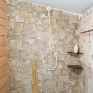 a bathroom with a shower with a stone wall at Phusam Big Resort in Ko Mook