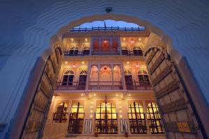 a large building with a balcony on top of it at Raj Rajeshwari Haveli in Jaipur