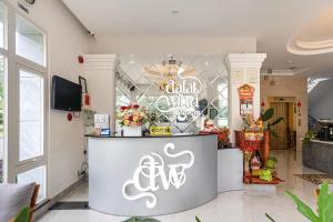 a restaurant with a counter with a sign on it at Dalat Wind Hotel in Da Lat