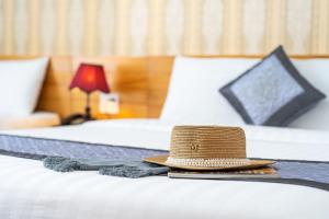 a straw hat sitting on top of a bed at Dalat Wind Hotel in Da Lat