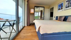 sypialnia z łóżkiem oraz balkon ze stołem w obiekcie Ferienwohnung A102 mit Komfort in Strandnähe mit Terrasse und Meerblick in 10ter Etage PARKING FREE w mieście Międzyzdroje