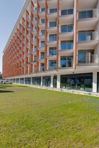apartamentowiec z trawnikiem przed nim w obiekcie Apartments Mazowiecka Pobierowo by Noclegi Renters w Pobierowie +37 zdjęć
