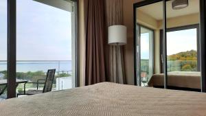 1 dormitorio con 1 cama y balcón con vistas. en Ferienwohnung A102 mit Komfort in Strandnähe mit Terrasse und Meerblick in 10ter Etage PARKING FREE en Międzyzdroje