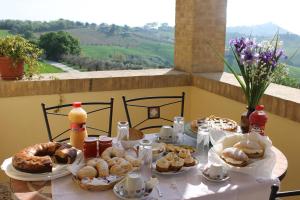 una mesa cubierta con platos de repostería y bebidas en Verdemare, en Acquaviva Picena