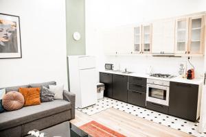 a living room with a couch and a kitchen at Stylish and Spacious ! Central location Kazincy Netflix in Budapest