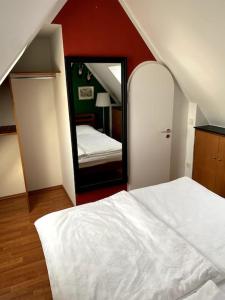 1 dormitorio con cama blanca y espejo en super zentral begehrte Wohnlage Parkplatz vor Haus en Núremberg