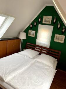 1 dormitorio con cama blanca y pared verde en super zentral begehrte Wohnlage Parkplatz vor Haus en Núremberg