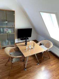 a table with chairs and a television in a room at super zentral begehrte Wohnlage Parkplatz vor Haus in Nuremberg