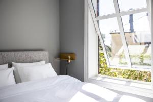 1 dormitorio con cama blanca y ventana abierta en Frogner House - Uranienborg en Oslo