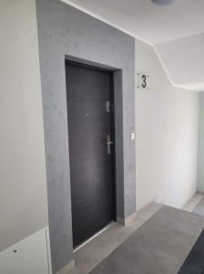 czarne drzwi w pokoju ze ścianą w obiekcie Kawalerka Wałowa 3 w Wejherowie