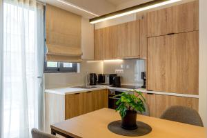 a kitchen with wooden cabinets and a table with a plant at IO SUITES in Athens