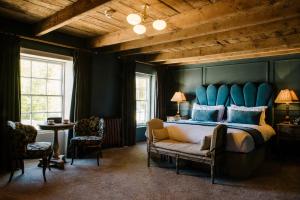 um quarto com uma cama grande e uma cabeceira azul em Le Petit Chateau & William de Percy em Otterburn