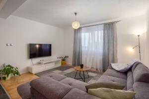 ein Wohnzimmer mit einem Sofa und einem TV in der Unterkunft Casa della Cava in Trogir
