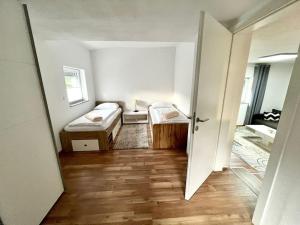 Cette petite chambre comprend deux lits et un couloir. dans l'établissement AB Apartment Moderne Zweizimmerwohnung, à Villach