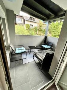 uma varanda com cadeiras e uma mesa na varanda em AB Apartment Moderne Zweizimmerwohnung em Villach