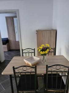a dining room table with a vase of flowers on it at Gästewohnung 2 in Oschersleben