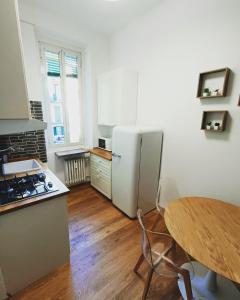 a kitchen with a white refrigerator and a table at Amio Apartment - next to M5 Ca Granda in Milan