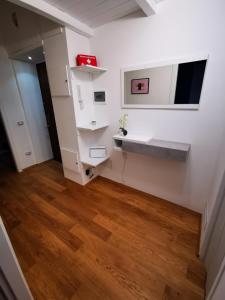 Habitación con paredes blancas y suelo de madera. en Amio Apartment - next to M5 Ca Granda, en Milán