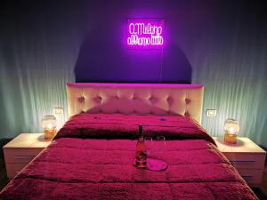 a bedroom with a bed with a pink neon sign at Amio Apartment - next to M5 Ca Granda in Milan