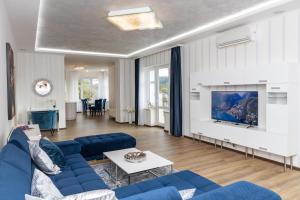 a living room with a blue couch and a tv at Rezidence Vyhlídka in Karlovy Vary