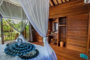 ein Schlafzimmer mit einem Bett in einem Zimmer mit Holzwänden in der Unterkunft Pondooks Joglo in Nusa Lembongan