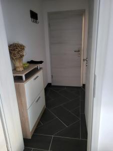 a bathroom with a door and a black tile floor at Gästewohnung 2 in Oschersleben