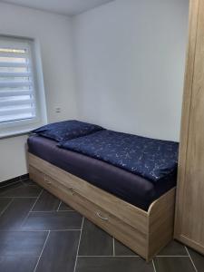 a small bed in a room with a window at Gästewohnung 2 in Oschersleben