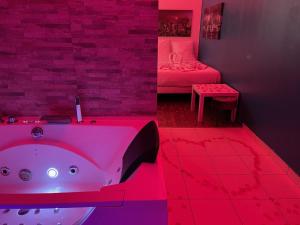 a bathroom with a tub and a bedroom with a bed at SPA Enzo Appartement avec Jacuzzi Privatif in Lyon