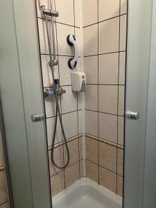 a shower with a hose in a bathroom with a sink at Hotel Turkovia in Turek