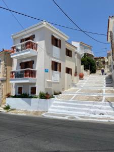 a white building with stairs leading up to it at Archo Suites Pythagoreio in Pythagoreio