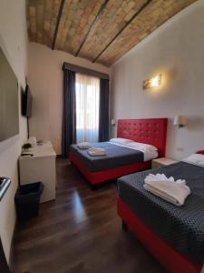 um quarto de hotel com duas camas e uma janela em Laterani DFM em Roma