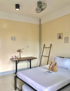 Cette chambre comprend un lit et une table avec une chaise. dans l'établissement Hanna's Inn, El Nido, à El Nido